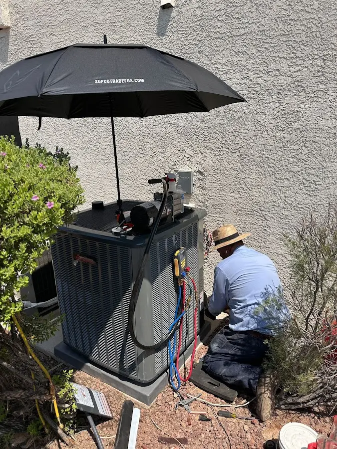 HVAC technician performing outdoor AC maintenance in Cottonwood Heights